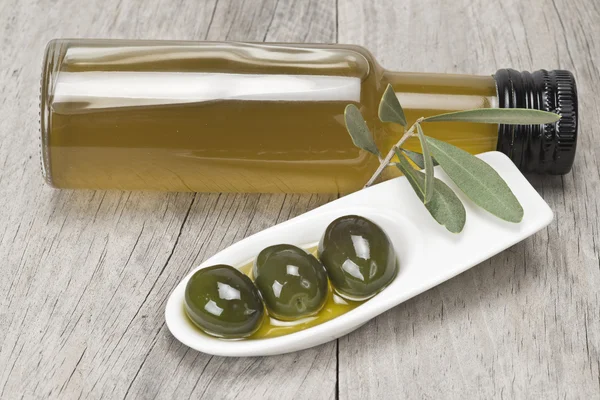 Virgin olive oil and green olives — Stock Photo, Image
