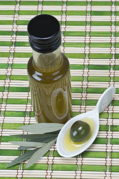Natives Olivenöl auf einer Bambusmatte — Stockfoto