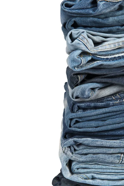 Stapel blauer Jeans vor weißem Hintergrund — Stockfoto