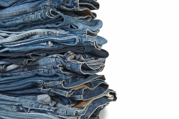 Stapel blauer Jeans vor weißem Hintergrund — Stockfoto