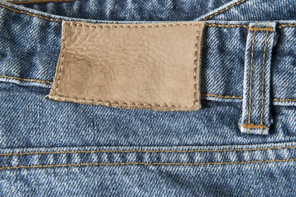 Jeans with empty leather label — Stock Photo, Image