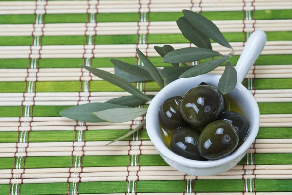 Olives in a china spoon — Stock Photo, Image