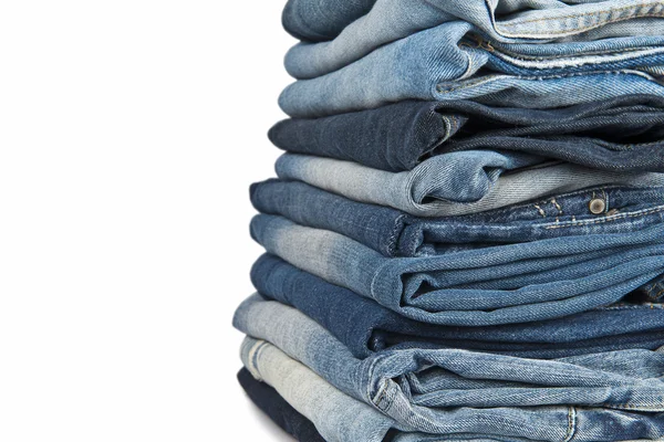 Stapel blauer Jeans vor weißem Hintergrund — Stockfoto