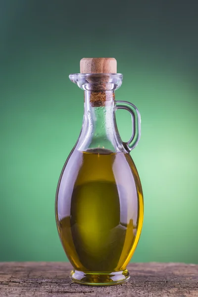 Μπουκάλι ελαιόλαδο με επίκεντρο πράσινο φόντο — Φωτογραφία Αρχείου