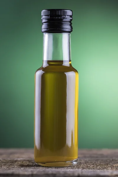 Frasco de aceite de oliva con fondo de foco verde —  Fotos de Stock