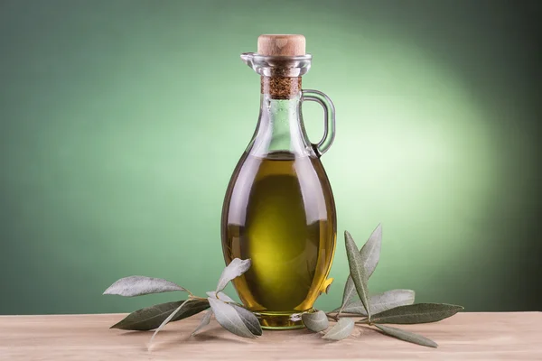 Botol minyak zaitun dengan latar belakang lampu sorot hijau — Stok Foto
