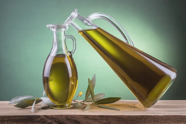 Bouteilles d'huile d'olive sur fond vert — Photo