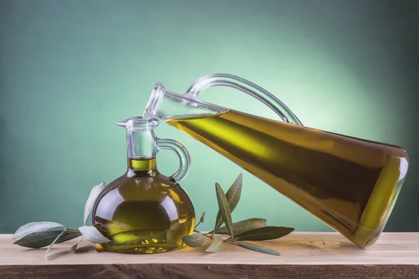 Olive oil bottles on a green spotlight background — Stock Photo, Image