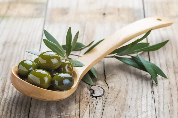 Houten lepel met olijven en olie — Stockfoto