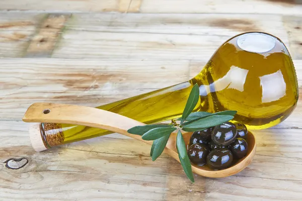 Розумна пляшка оливкової олії та ложки з оливками — стокове фото