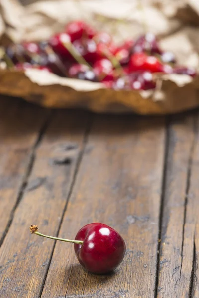 A wrapping paper with cherries on the table — Stock Photo, Image