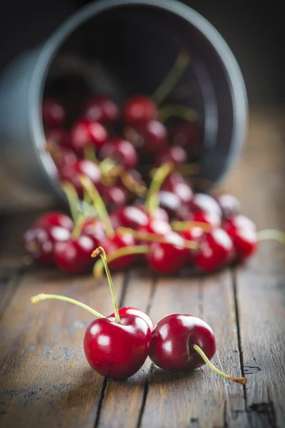 Little brass bucket of cherries on a table — Stock Photo, Image