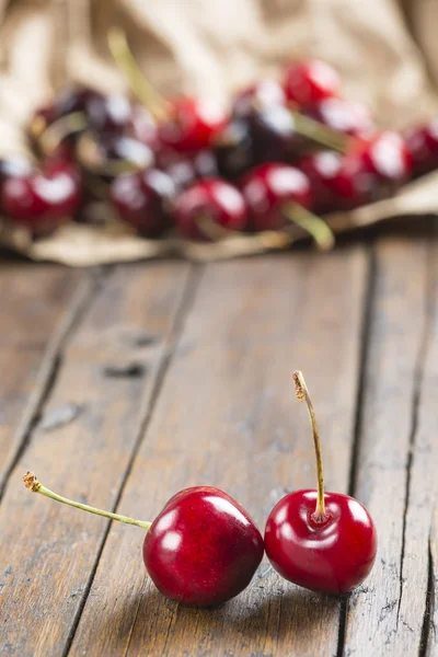 Un papel de regalo con cerezas sobre la mesa — Foto de Stock