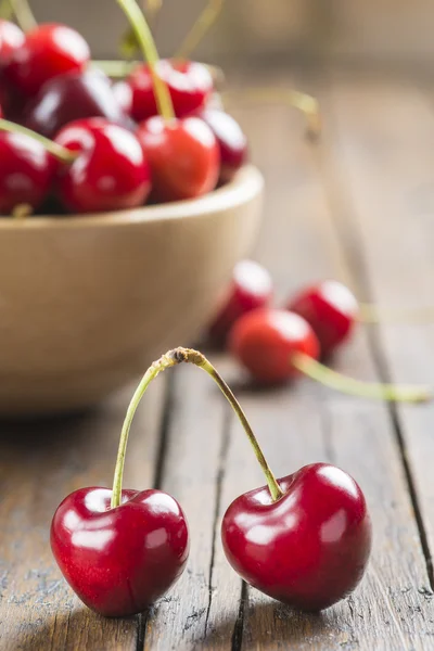 Wooden bowl of cherries on the table — Stock Photo, Image