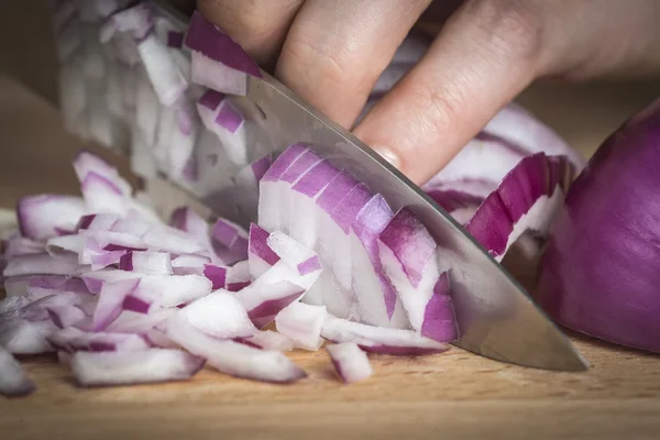 Chef choppig una cebolla roja con un cuchillo — Foto de Stock