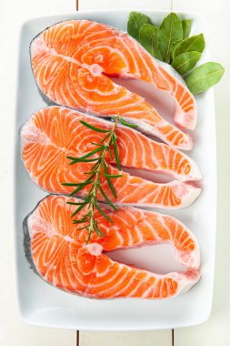 Mutfak masasında pişmemiş taze somon filetoları.