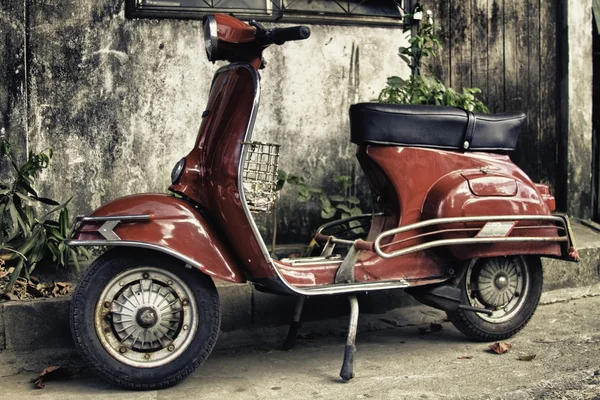 Припаркованный старый красный мопед — стоковое фото