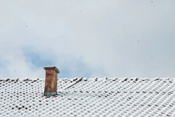 Старый дымоход на снежной крыше — стоковое фото