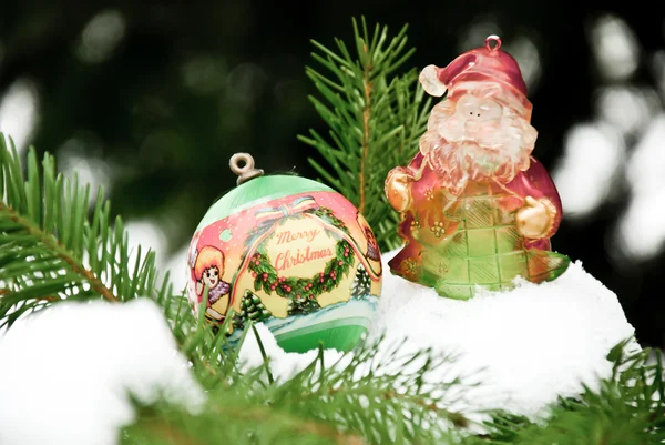 Weihnachtskugel und Weihnachtsmann auf Kiefer - Ast mit Schnee — Stockfoto