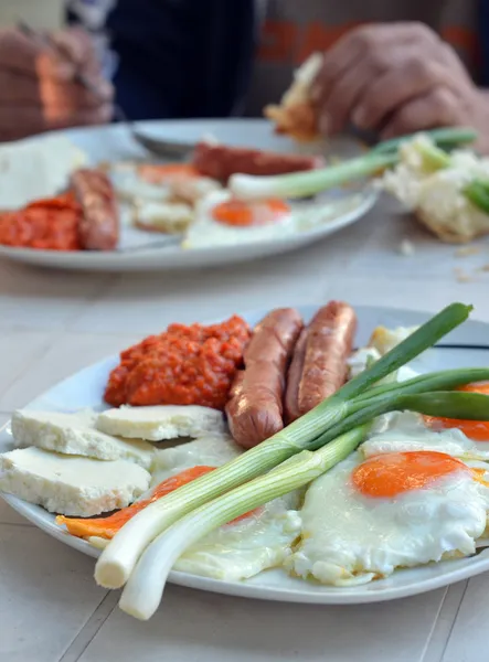 Аппетитный завтрак с яичницей и жареными колбасами — стоковое фото
