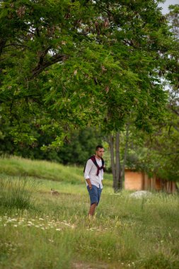 Beyaz gömlekli ve kazaklı bir gencin moda portresi.