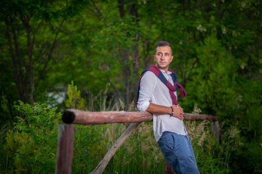 Beyaz gömlekli ve kazaklı bir gencin moda portresi. .