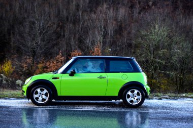 Ohrid,Horth Macedonia, April, 2022 : Green Mini Cooper One produced 2004 year on the road to Ohrid city in N.Macedonia. clipart