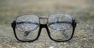 raindrops on reading glasses placed on a concrete background