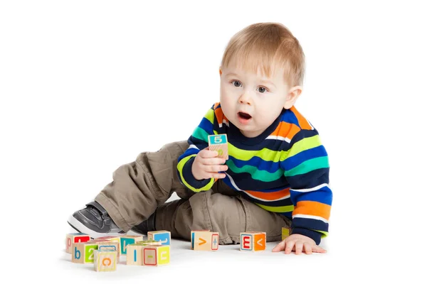 Bebê brincando com cubos de brinquedo de madeira com letras. Alfabeto de madeira — Fotografia de Stock