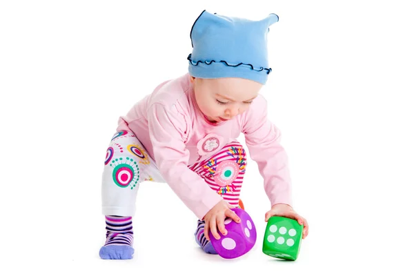 Baby is playing with toys over white background. Funny little kid playing with cup toys — Stok fotoğraf