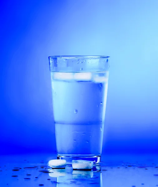 Glass of water on blue background. water with ice in glass — Stock Photo, Image