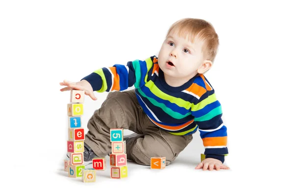 Bebê brincando com cubos de brinquedo de madeira com letras. Alfabeto de madeira — Fotografia de Stock