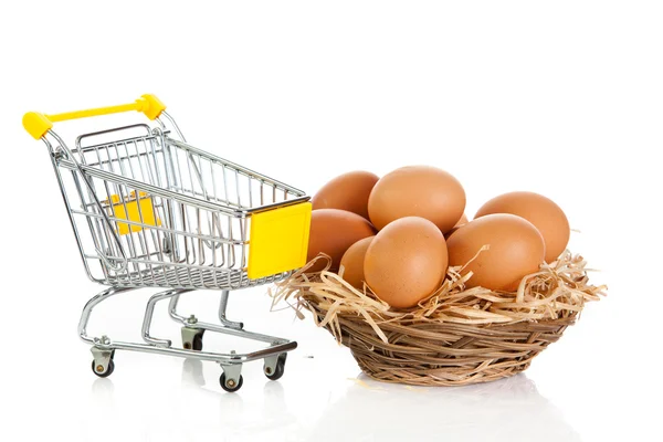 Eggs in the shopping cart isolaten in white. Brown eggs in the b — Stock Photo, Image