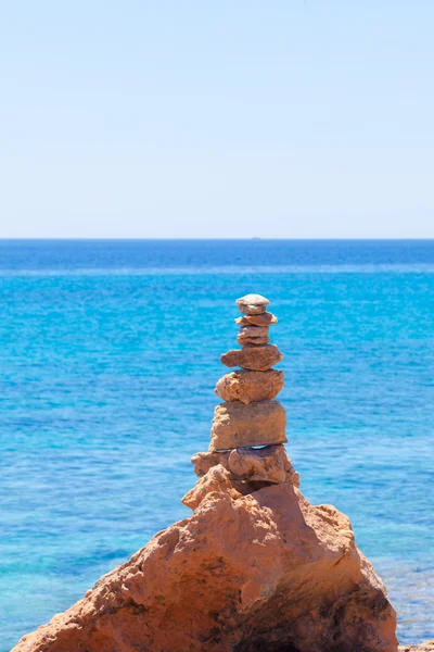 Pietre bilanciate, ciottoli impilati contro il mare blu . — Foto Stock