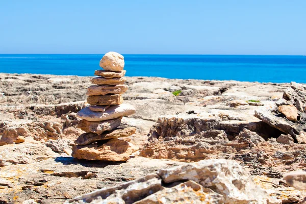 Piedras balanceadas, piedras apiladas contra el mar azul . — Foto de Stock