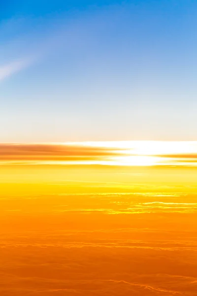 Puesta de sol sobre las nubes. Vista del atardecer desde la ventana del avión — Foto de Stock