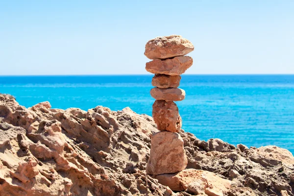 Vyvážené kameny, oblázky komíny proti modré moře. — Stock fotografie