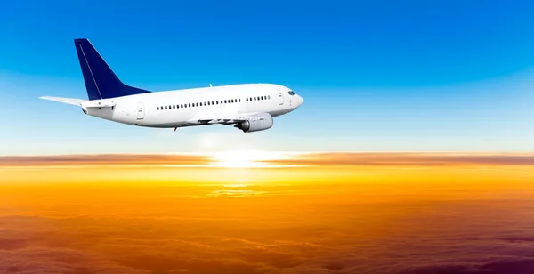 Avión en el cielo al atardecer. Un avión de pasajeros en el cielo — Foto de Stock