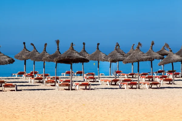 Пляжный пейзаж с зонтиком и шезлонгами — стоковое фото