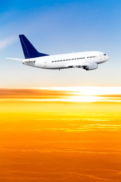 Avión en el cielo al atardecer. Un avión de pasajeros en el cielo — Foto de Stock