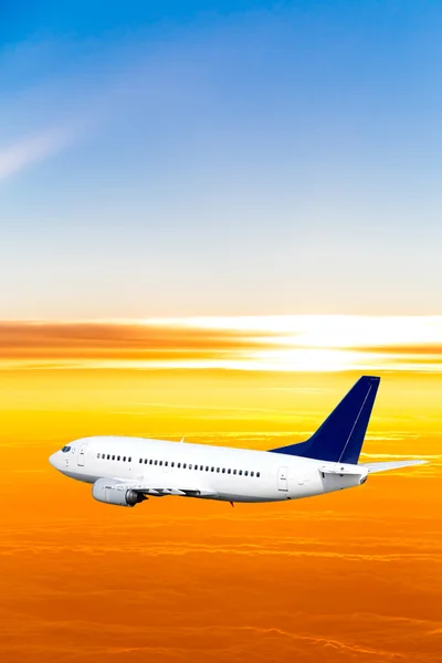 Vliegtuig in de lucht bij zonsondergang. een passagiersvliegtuig in de hemel — Stockfoto