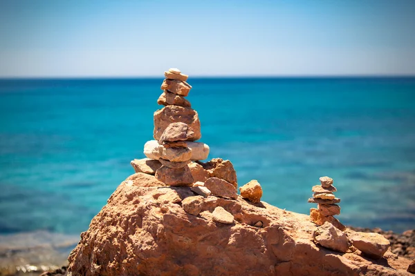Equilibrio de piedras, piedras apiladas sobre el mar azul — Foto de Stock