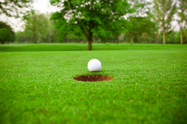 Golf ball op lip van cup — Stockfoto