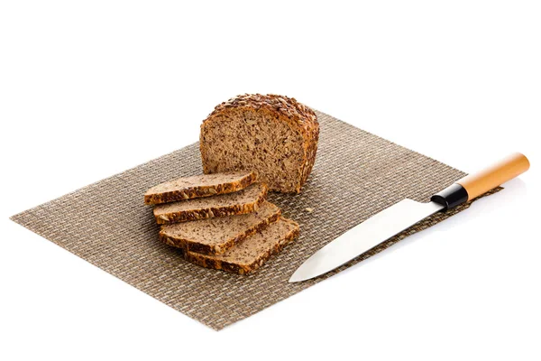 Fresh bread being sliced on a wooden cutting board with a bread — Stock Photo, Image