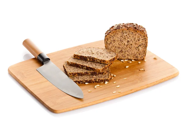 Fresh bread being sliced on a wooden cutting board with a bread — Stock Photo, Image