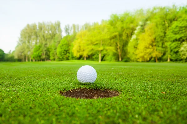 Golf ball on lip of cup Royalty Free Stock Photos