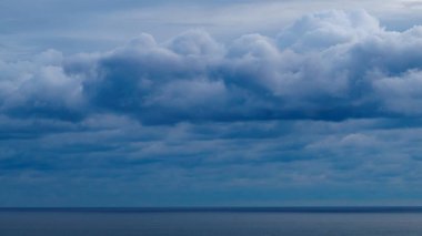 Panoramik parlak mavi deniz, mavi gökyüzü ile kabarık beyaz bulutlar 