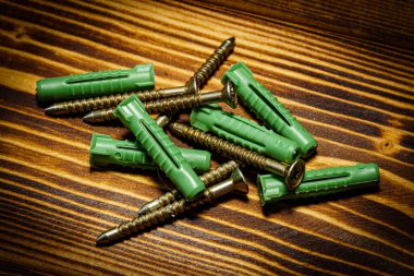 Tahta bir masanın üzerine konmuş bir dizi vidanın yakın plan çekimi.