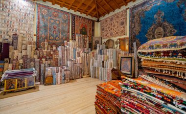 Bir halı dükkanındaki çeşitli renklerde katlanmış halılar.