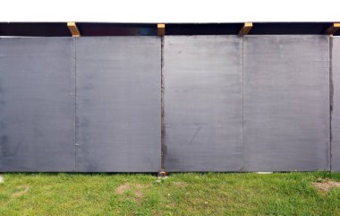 İnşaat alanı çitleri ahşap reçine işlemeli siyah yonga tahtalarından yapılmış. İzole edilmiş 